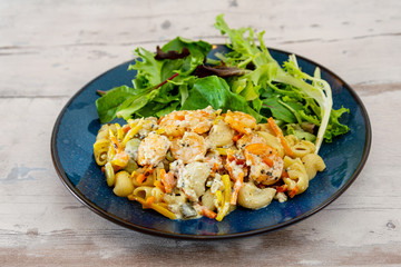 Cooked pasta with peeled shrimp, coconut milk sauce and broccoli