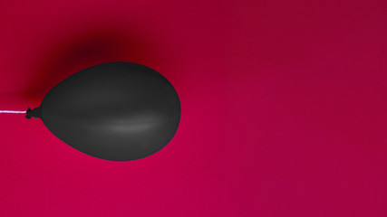 Black balloon on red background
