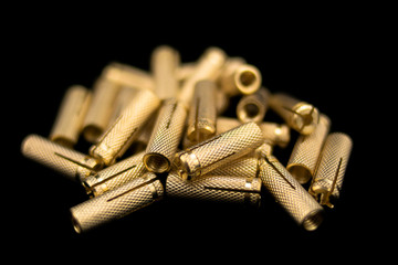 Heap of shiny metal studs on black background