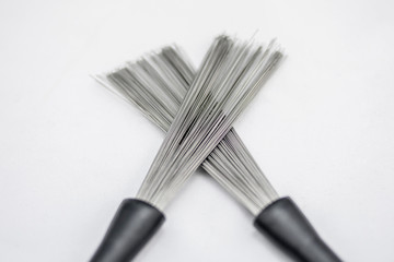 Drummer brushes crossed and bright on white background