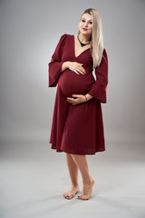 Pregnant young woman in red dress