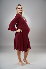 Fototapeta premium Pregnant young woman in red dress