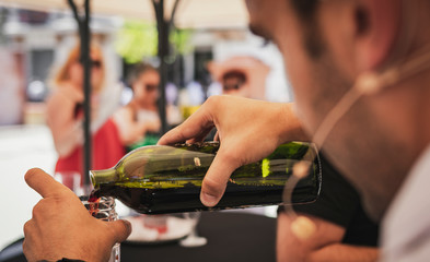 Sommelier serves wine with a newly uncorked bottle without a bottleneck