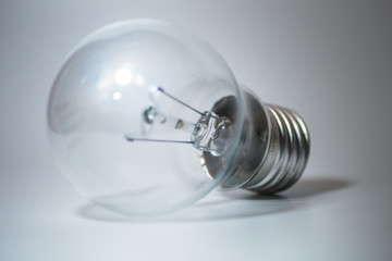 close-up of a standard E27 light bulb on a bright white background. The transparent glass, metallic...