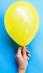 Person holding yellow balloon