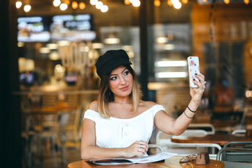 Chica en cafetería con el móvil