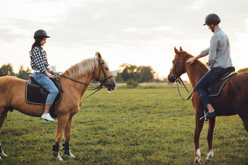 Portrait of happy loving couple spending time with horses on ranch