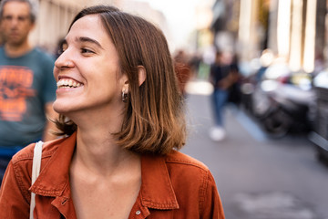 Blonde girl in the middle of the street with happy expression looking to the side