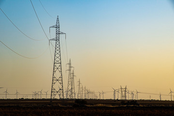 Un viento lejano con turbinas eólicas  en un entorno de puesta de sol poético, que sirve como una imagen perfecta para la energía verde sostenible renovable.