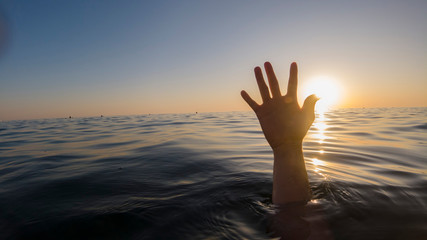 Fototapeta na wymiar hand of a drowning man in the sea