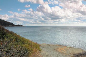 seascape view from the high shore to the coastal mountains sea, sky and white clouds