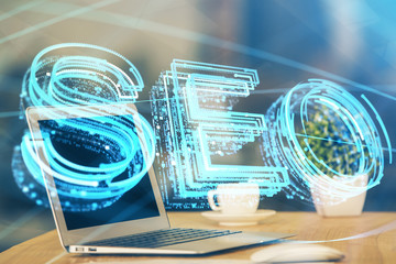 Multi exposure of table with computer and seo drawing hologram. Search optimization concept.