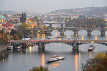 Fototapeta na wymiar Prague bridges over Vltava river in historical part of the city. Autumn. Evening. Cloudy sky. Fog. Prague, Czech Republic.