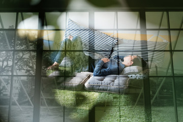 asian teenager man listening to music from smart mobile phone while lying on floor at home