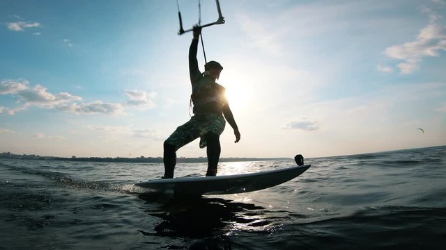 Athlete surfing on board with kite.