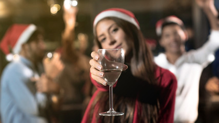 Group of friends celebrating christmas at home, focus on champagne glasses.