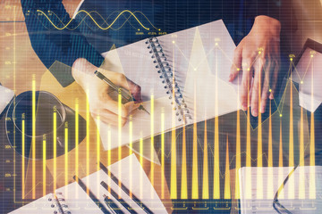 Forex graph on hand taking notes background. Concept of research. Multi exposure