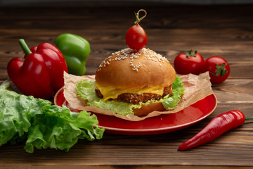 hamburger with meatballs and cheese in a red plate on a wooden background