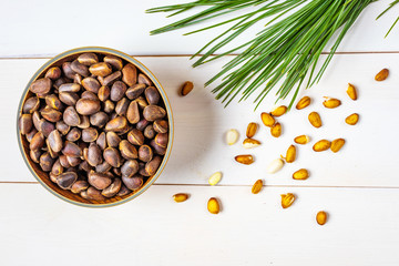 Cedar cone, nuts and a branch of Siberian cedar on a light wooden background. The concept of...