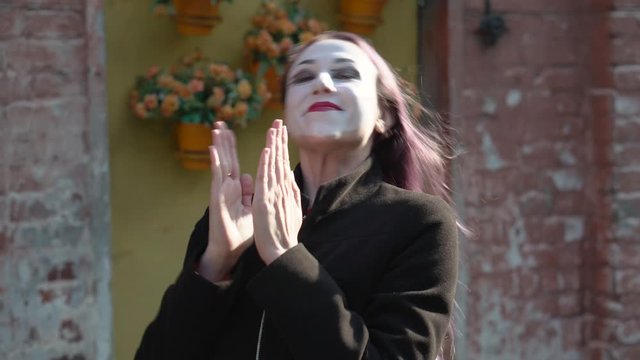 Mime imitates an imaginary rejoices and claps his hands.