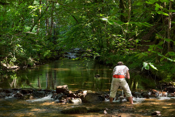 un photographe dans une rivière. Un homme debout dans une rivière.