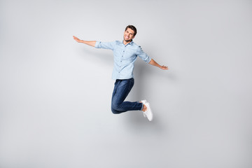 Fototapeta na wymiar Full length body size side profile photo of cheerful handsome positive attractive man wearing white sneakers pretending to be airplane isolated over grey color background