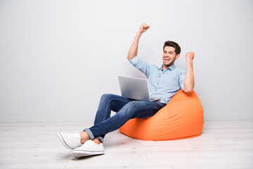 Full length body size turned photo of cheerful positive nice attractive man sitting rejoicing with...