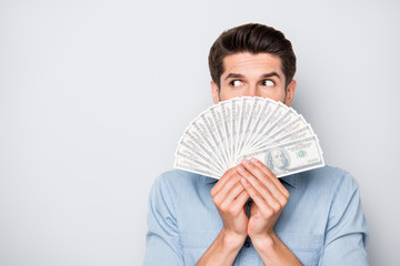 Photo of man looking out of money held with his hands into empty space isolated over grey color background