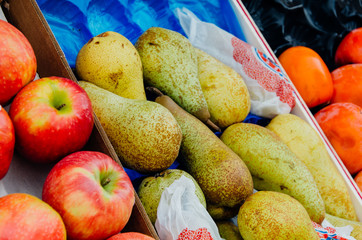 des pommes, des poires et des oranges sur un étal de marché