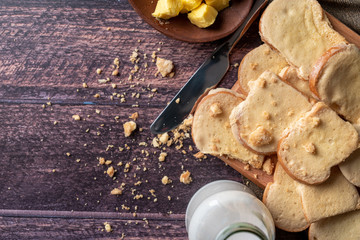 Fresh bread and wooden tray on wooden table. Top view with space for your text