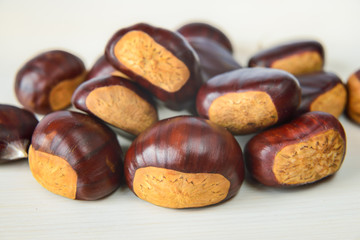 Castagne mature appena raccolte su tagliere bianco