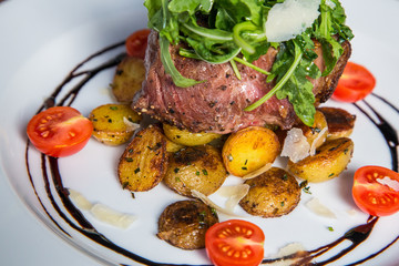 Grilled steak with fresh tomatoes and garlics.