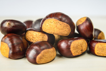 Castagne mature appena raccolte su tagliere bianco