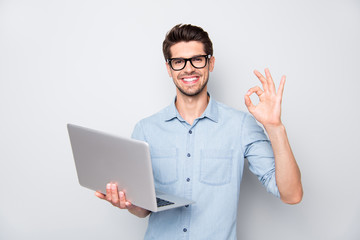 Photo of beaming brown haired cheerful positive kind friendly business trainer having done his teaching project to be shown to his students showing ok sign isolated over grey color background - obrazy, fototapety, plakaty