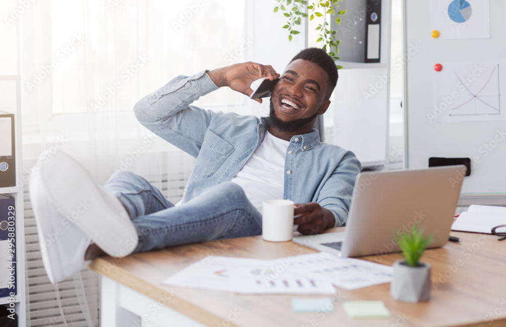 Poster joyful black manager talking on phone while having break at work