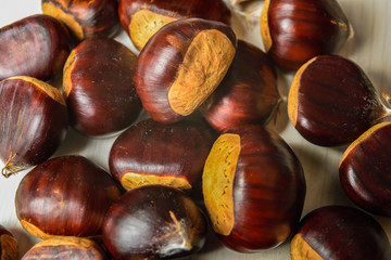Castagne mature appena raccolte su tagliere bianco