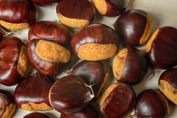 Castagne mature appena raccolte su tagliere bianco