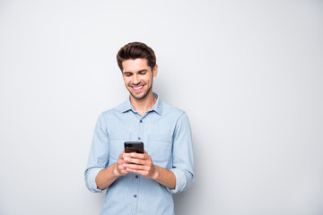 Portrait of positive cheerful man stand copyspace have fun use his smartphone type new post in blog...