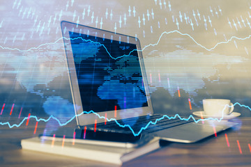 Financial chart drawing and table with computer on background. Double exposure. Concept of international markets.