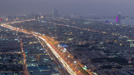 Naklejka na ściany i meble Aerial view to traffic on Sheikh Zayed road and intersection day to night timelapse, Dubai, United Arab Emirates