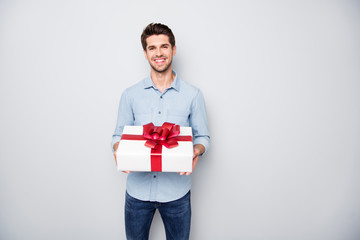 Portrait of positive charming lover man hold gift box present for 14-february 8-march feel content enjoy holiday wear style denim jeans clothing isolated over grey color background