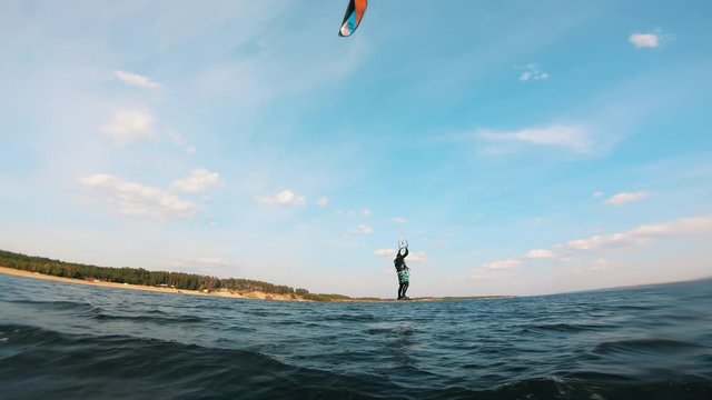 Person jumps while riding a kiteboard.