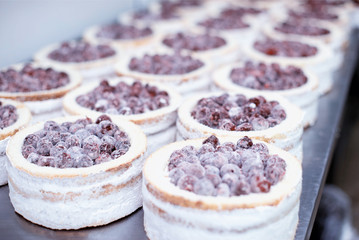 Making biscuit cakes with condensed milk in the confectionery industry with fresh cherry, food industry, sweetness
