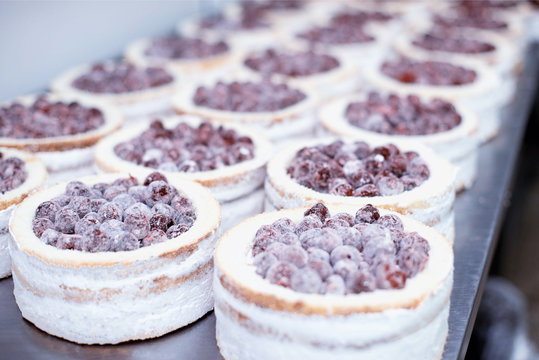 Making biscuit cakes with condensed milk in the confectionery industry with fresh cherry, food industry, sweetness