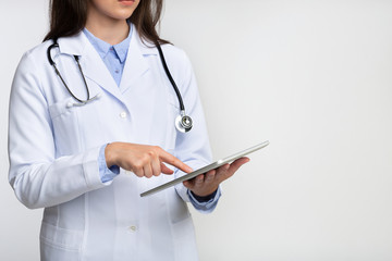 Unrecognizable Lady Doctor Using Tablet Computer Standing In Studio, Cropped