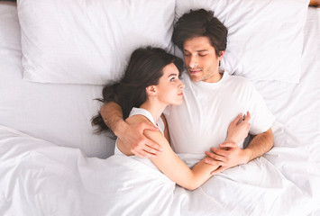 Young loving couple sleeping in bed and hugging