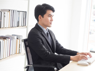 A young businessman is working hard at his company office to lead his company successfully.