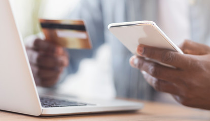 Black businessman paying his bills online using app in smartphone