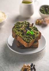 healthy meal of pesto sauce on a rye bread, on a light plate, on a marble backdrop