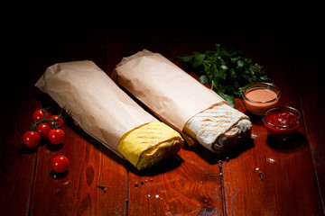 Doner kebab (shawarma), on a dark wooden board background.